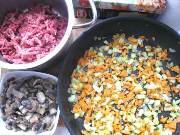 Лук порезать кубиками. Морковь порезать на мелкие кубики, стебель сельдерея порезать на небольшие кусочки. Пармезан натереть на крупной терке. Мясо прокрутить через мясорубку.Обжарить овощи – морковь, половину лука и сельдерей – на оливковом масле. Лук порезать кубиками. Морковь порезать на мелкие кубики, стебель сельдерея порезать на небольшие кусочки. Пармезан натереть на крупной терке. Мясо прокрутить через мясорубку.Обжарить овощи – морковь, половину лука и сельдерей – на оливковом масле.