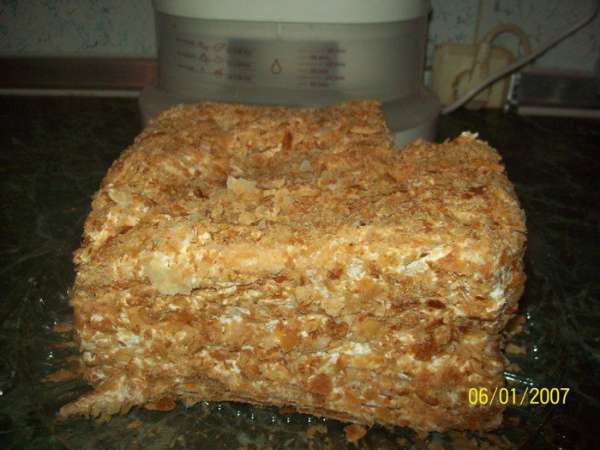 Молоко, желтки яиц, муку, 140 г сахара, ваниль (по вкусу) смешать в холодном виде(не должно быть комков). Эту смесь варить до загустения на водяной бане (н е  д о в о д и т ь  д о  к и п е н и я). Оставшиеся белки (все!) взбить с 50 граммами сахара (отделили от 190 г). Взбитые белки добавить в крем. Перемешать. Коржи ложить друг на друга, обильно смазывая каждый кремом. Обильно смазать кремом верхний корж и бока торта. Весь торт посыпать присыпкой (размятые коржи).
