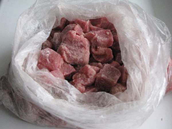 В полиэтиленовый пакет насыпать крахмал, выложить  мясо и хорошенько встряхнуть. Крахмал равномерно распределится по мясу.