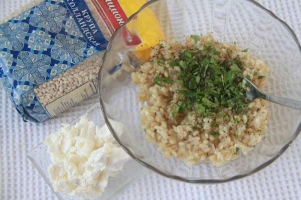 В перловую крупу добавить зелень и фету, перемешать, посолить по вкусу — начинка готова.