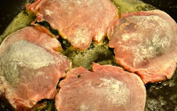 В глубокой тяжелой сковороде разогреть оливковое масло. Мясо слегка обвалять в муке, стряхнуть ее излишки и обжарить в масле с обеих сторон, по 5 минут с каждой стороны. Обжаренное мясо выложить на блюдо, сохранять в тепле. 