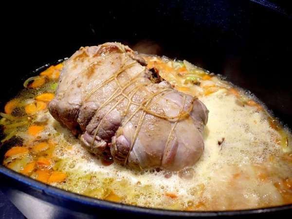 Выльем в жаровню к мясу и овощам вино, перемешаем его с овощами и дадим в течение нескольких минут увариться. Теперь зальем 500 мл кипятка в жаровню, перемешаем соус и, уменьшив огонь, добавим оставшуюся начинку. 