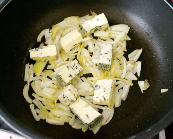 Сыр Рокфор порезать кусочками и добавить к луку.
