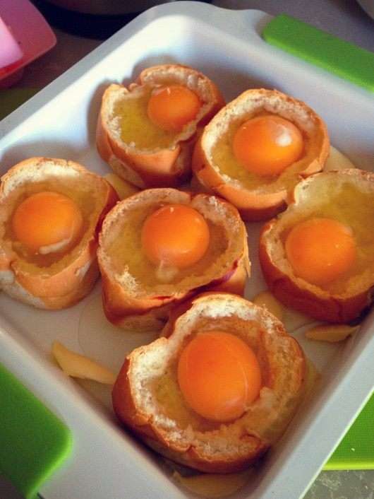 Вбиваем аккуратно в каждую булочку сырое яйцо...