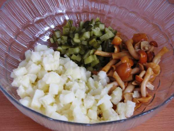 Пока маринуется лук, нарезать отварной картофель и огурцы мелким кубиком выложить в миску. Маринованные грибы откинуть на дуршлаг, дать стечь маринаду. Добавить к картофель и огурцам. Грибы можно взять любые, в  моем случае маринованные опята.