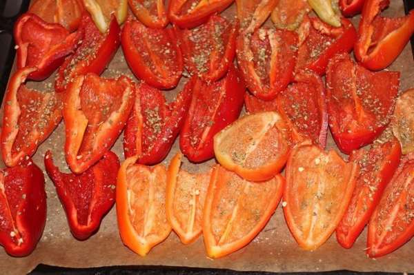 Противень застелить пергаментной бумагой, выложить половинки перцев, посолить, посыпать травами, сбрызнуть маслом и отправить в духовку, разогретую до 120 гр. С на 4 часа. 