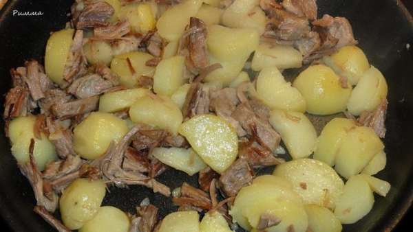 Возьмите сковороду в которой вы будете запекать блюдо. Обжарьте мясо и картофель на оливковом масле до золотистого цвета.