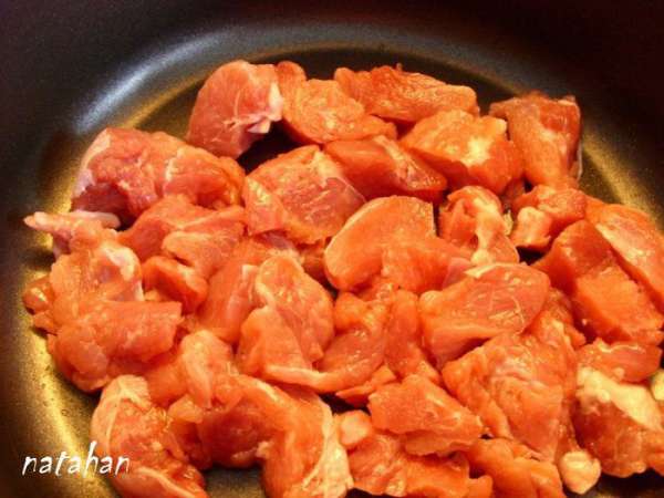 Голень обмыть, обсушить и срезать мясо, из которого удалить жесткие сухожилия. Мясо нарезать на кусочки, сложить его в кастрюлю-котелок  и поставить на плиту ( максимальная температура). Обжарить без масла 2 минуты постоянно переворачивая. Затем влить растительное масло и уменьшить нагрев плиты до среднего. Обжаривать ещё 5-7 минут.
