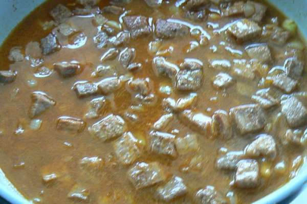 добавить чеснок  ,присыпать красным перцем,и залить мясо горячей водой или бульоном(около стакана).Готовим приблизительно 40 минут до готовности мяса.