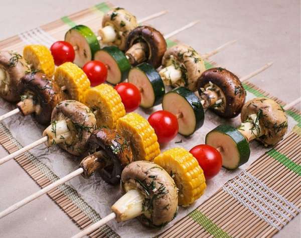 А теперь самое интересное: овощи попеременно нанизываем на шампур. И если для мясного шашлыка я использую квадратные деревянные шампуры, то для овощного лучше выбрать круглые шампуры, потому что на них грибы и овощи нанизываются гораздо легче и не вращаются. Получилось подобие овощного светофора с грибами – выглядит очень по-летнему. 