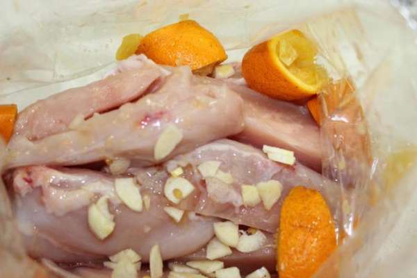 Куриную грудку освободить от кожи и грудной кости, нарезать на продольные кусочки, уложить в пакет для запекания. Добавить нарезанный чеснок, сок двух апельсинов и нарезанную на дольки кожуру апельсинов. Куриную грудку освободить от кожи и грудной кости, нарезать на продольные кусочки, уложить в пакет для запекания. Добавить нарезанный чеснок, сок двух апельсинов и нарезанную на дольки кожуру апельсинов.