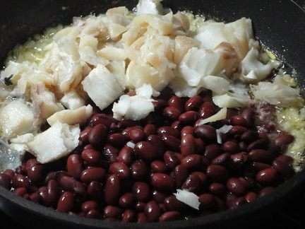 Сюда же выложить рыбу и фасоль, посолить и поперчить по вкусу и держать на небольшом огне 15 минут.