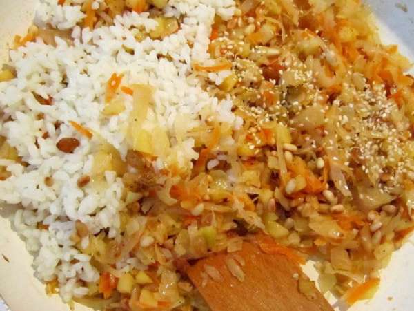К капустной массе добавить обжаренные орешки, кунжутные семечки, отваренный рис, перемешать. Приправить перцем.