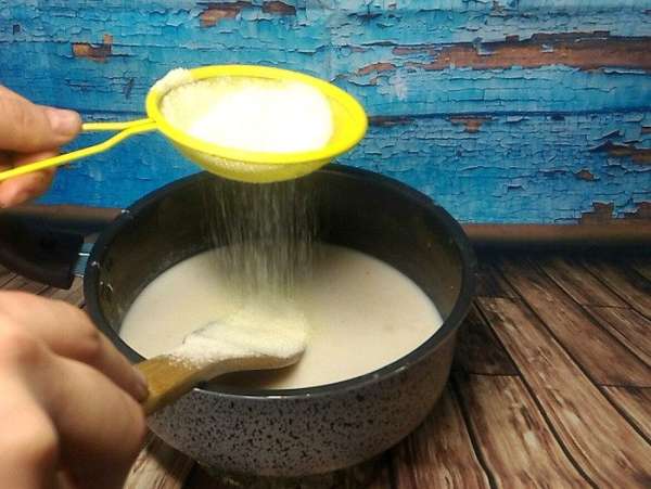При постоянном помешивании вводим кукурузную муку (сразу просеиваем) и сахар, и возвращаем на плиту. Смесь должна загустеть, поэтому на небольшом огне доводим все до нужной консистенции. Мешать не забываем, чтобы не образовались комочки, от которых будет сложно избавиться. При постоянном помешивании вводим кукурузную муку (сразу просеиваем) и сахар, и возвращаем на плиту. Смесь должна загустеть, поэтому на небольшом огне доводим все до нужной консистенции. Мешать не забываем, чтобы не образовались комочки, от которых будет сложно избавиться.