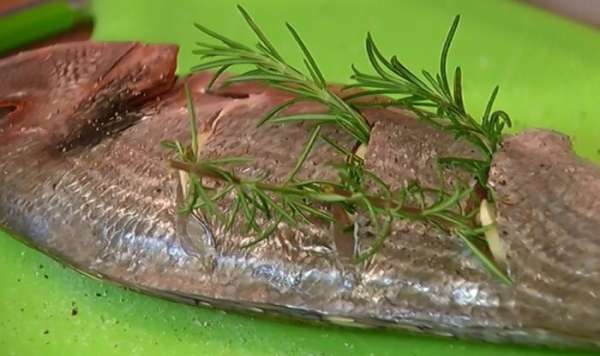 Начинить разрезы чесноком и свернутыми веточками розмарина так, чтобы кончик розмарина торчал из разреза (если веточки слишком длинные — разрезать пополам).