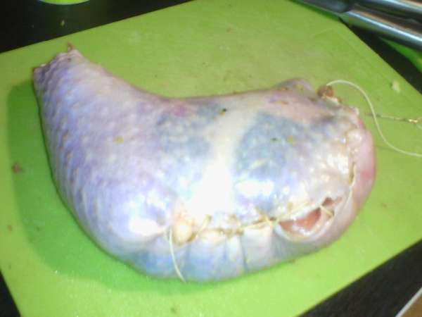 Смазать соевым соусом мясо индейки, наполнить фаршем, зашить по краям всё бедро. 