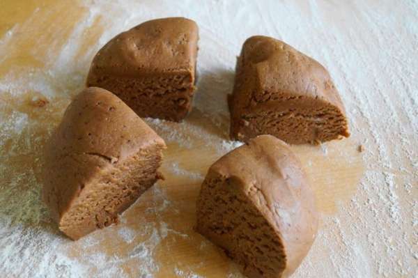 Немного посыпаем мукой стол, выкладываем на него тесто и делим на 4 части