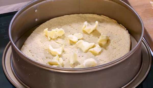 Оставшееся сливочное масло нарезать кусочками и выложить половину на подпеченный корж. Оставшееся сливочное масло нарезать кусочками и выложить половину на подпеченный корж.