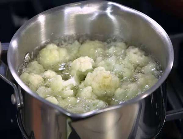 Цветную капусту разобрать на маленькие соцветия и опустить на несколько минут в кипящую воду, затем откинуть на дуршлаг.