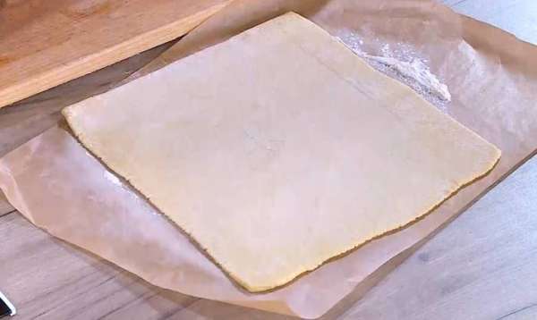 Рабочую поверхность посыпать мукой и раскатать предварительно размороженное тесто в тонкий пласт. Рабочую поверхность посыпать мукой и раскатать предварительно размороженное тесто в тонкий пласт.