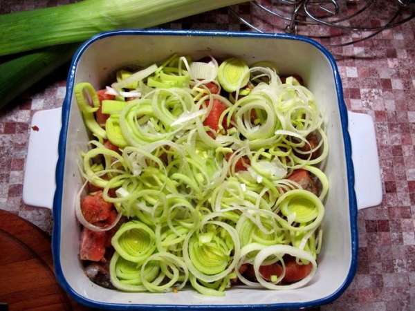 Лук-порей нарезать колечками и выложить поверх рыбы.