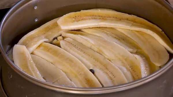 Посыпать корж с маслом частью шоколадных капель, небольшим количеством сахара и выложить плотным слоем ломтики бананов. Посыпать корж с маслом частью шоколадных капель, небольшим количеством сахара и выложить плотным слоем ломтики бананов.