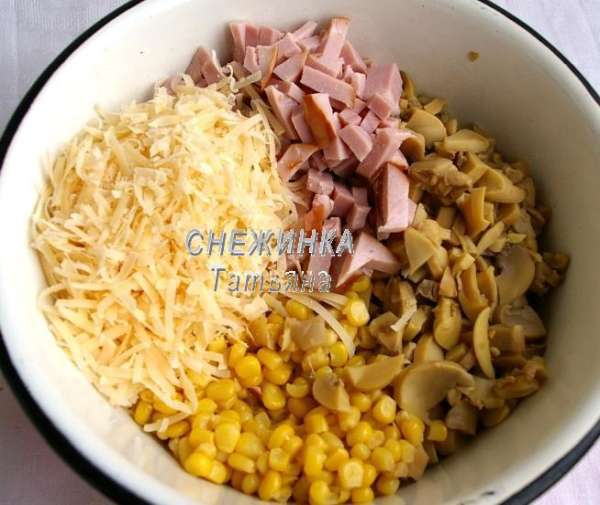Ветчину и шампиньоны нарезаем небольшими кусочками, кубиком или соломкой. Шампиньоны у меня были консервированные, но не маринованные, можно взять и свежие, только предварительно отварить в подсоленной воде. Сыр натираем на крупной тёрке. Соединяем всё в миске. Открываем банку кукурузы, сцеживаем жидкость и добавляем к остальным ингредиентам.