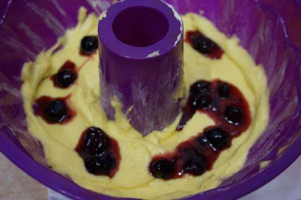 Выложить часть теста в форму, сверху немного варенья (по центру, немного вдавливая) и залить оставшимся тестом.