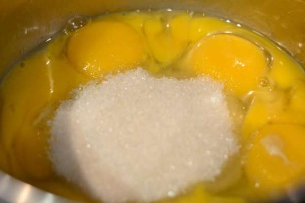 Яичные желтки и 2 целых яйца засыпать сахаром и отправить на плиту, включить средний огонь и варить, постоянно помешивая венчиком до небольшого загустения. Яичные желтки и 2 целых яйца засыпать сахаром и отправить на плиту, включить средний огонь и варить, постоянно помешивая венчиком до небольшого загустения.