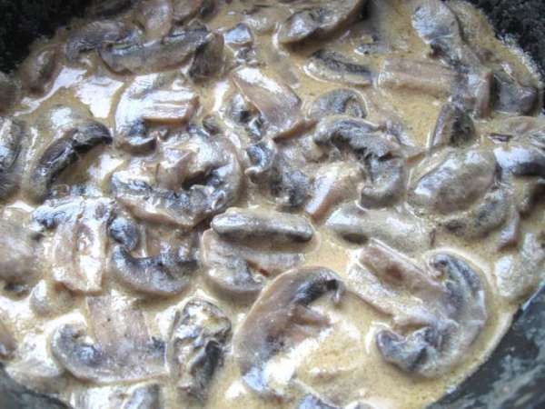 В сковороду, где остался мясной сок, влить белое вино, добавить шампиньоны, перемешать и дать вину немного выпариться. Затем влить сливки. Дать соусу немного загустеть, уварить на  медленном огне.