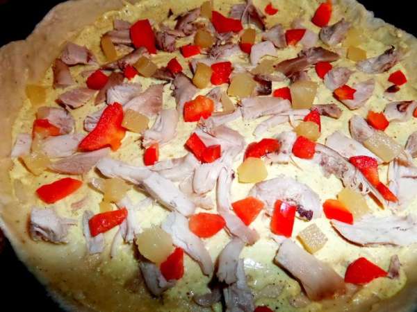 Выложить на пласт теста куриные кусочки, сладкий перец и ананас в кусочках.