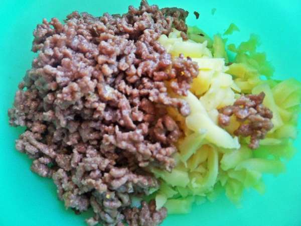 Смешать фарш с картофелем, посолить. Смешать фарш с картофелем, посолить.