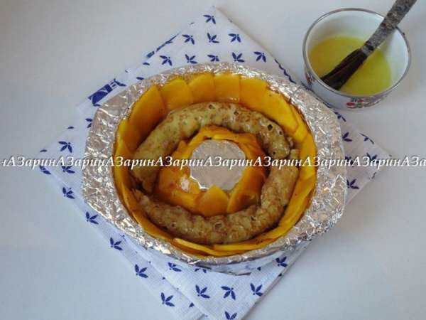 Затем выложить поверх тыквы блинные трубочки, смазывая их желтком.