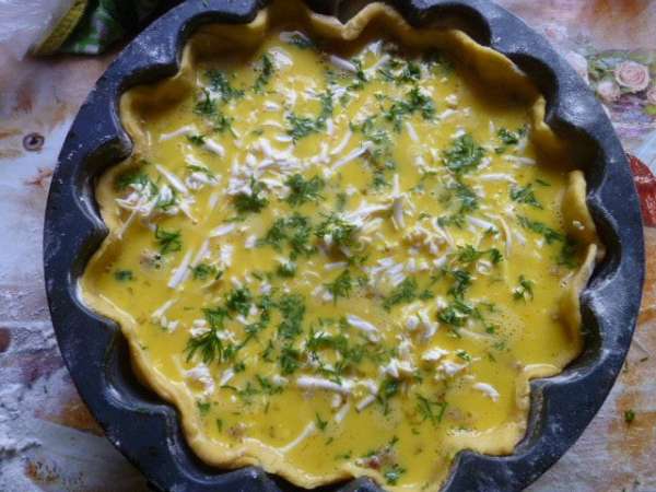 Залить мясную начинку омлетной массой, сверху посыпать тертым плавленным сыром и мелко нарезанным укропом.