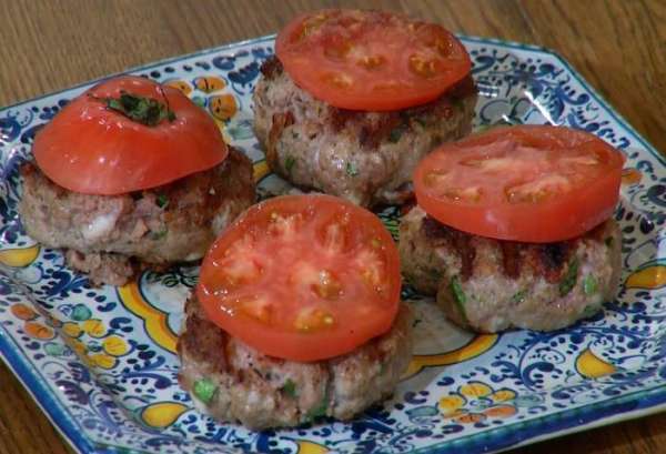 Помидор нарезать кружками и разложить на горячие котлеты.