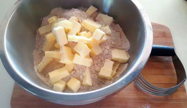 Добавьте порезанное кусочками холодное масло и, используя специальный нож для смешивания муки и масла (на фото), перетрите все до тех пор, пока масло будет собой представлять мелкие кусочки (как на посыпушку). Ту же самую работу можно также легко сделать вручную. Добавьте порезанное кусочками холодное масло и, используя специальный нож для смешивания муки и масла (на фото), перетрите все до тех пор, пока масло будет собой представлять мелкие кусочки (как на посыпушку). Ту же самую работу можно также легко сделать вручную.