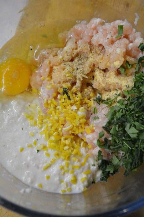 Куриное филе прокрутить через мясорубку с кусочком сала. Батон без корочек замочить в молоке и также прокрутить через мясорубку. В фарш добавить измельченную петрушку, чеснок через пресс, яйцо и цедру порезанную мелкими кубиками. Посолить и поперчить.