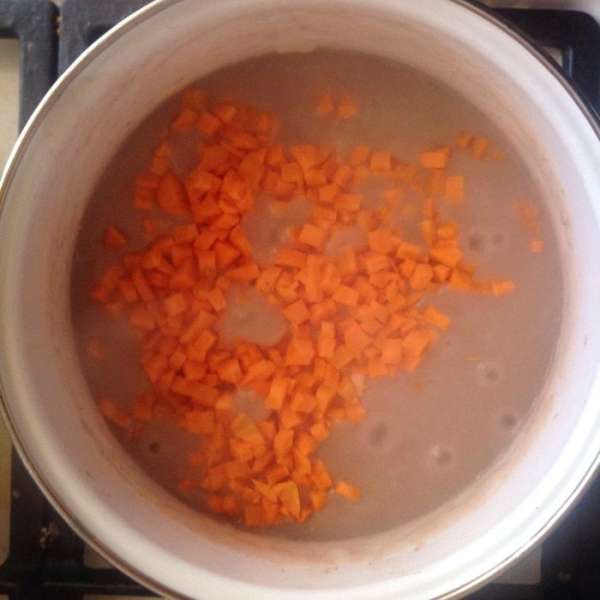 Очистить моркови и порезать кубиками. Добавить морковь в кастрюлю, перемешать, убавить огонь, накрыть крышкой и оставить тушиться 50-60 минут. В процессе тушения подливать воду.