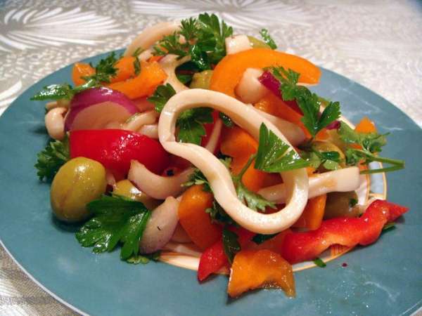 Смешать кальмары с овощами, посыпать зеленью петрушки и поставить салат в холодильник на 30 минут. Подавать холодным.