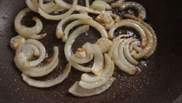 Лук нарезать крупными кольцами и обжарить в той же сковородке, что и кабачки. Лук нарезать крупными кольцами и обжарить в той же сковородке, что и кабачки.