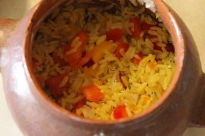 Выложить в горшочки часть риса с овощами. 
