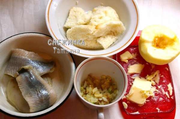 Подготовим все продукты для начинки. Селёдку режем крупными кусочками. Лук чистим, моем, нарезаем кубиком и обжариваем до мягкости на растительном масле. Белый хлеб заливаем небольшим количеством воды, чтобы он размок. Чистим яблоко от кожи и семян.
