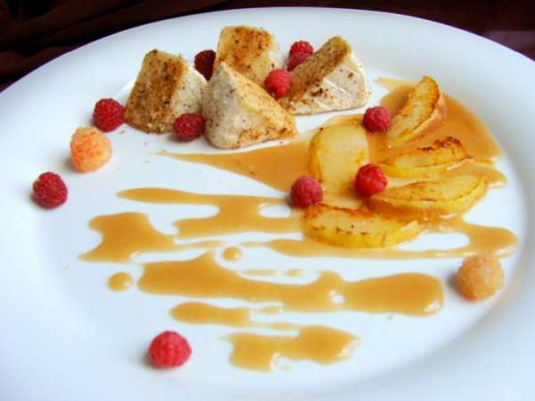 На тарелку выложить кусочки сыра. Рядом полить карамельным соусом, на него выложить горячую грушу. Украсить малинкой.