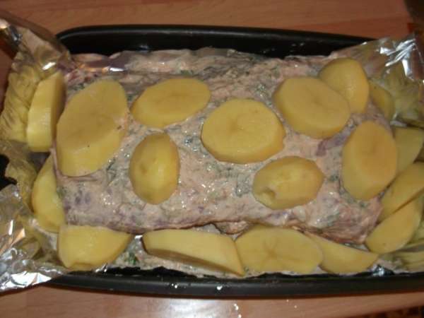 Обкладываем картошкой (по желанию, но уж больно хороша пропитанная мясным соусом), закрываем сверху фольгой, плотно запечатываем и ставим в разогретую до 220 гр духовку на час (каждый килограмм мяса берет час готовки, у меня 2 кг - значит 2 часа). Достаем готовое мясо, посыпаем оставшейся зеленью (аромат сногосшибательный), прикрываем фольгой и оставляем на 15 минут, нарезаем и подаем с гарниром.