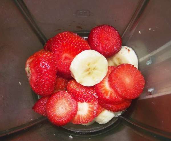 Нарезаем банан и клубнику в чашу блендера. Бокалы для коктейля отправляем в морозильную камеру.