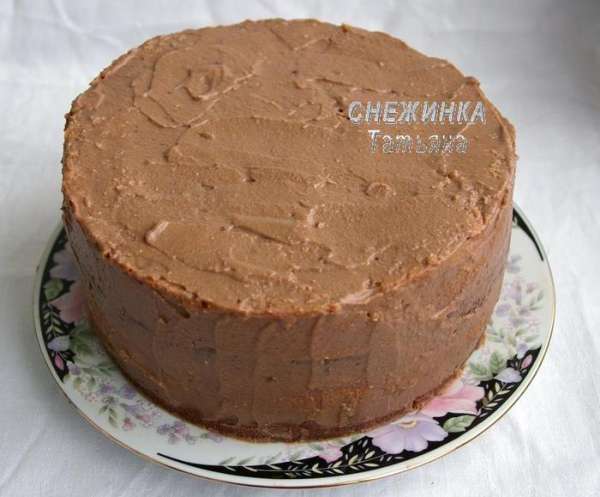 Следующим сверху кладём корж, в котором светлым будет самый большой круг, т.е. чтобы цвета чередовались в другом порядке по сравнению с первым коржом. Сверху – крем и вишня. Третий корж уже с большим тёмным кругом, крем, вишня и накрываем последним коржом. Обмазываем весь торт оставшимся кремом.