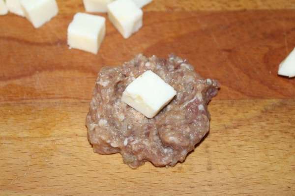 Сыр нарезать небольшими кусочками, выложить на кусочки фарша.