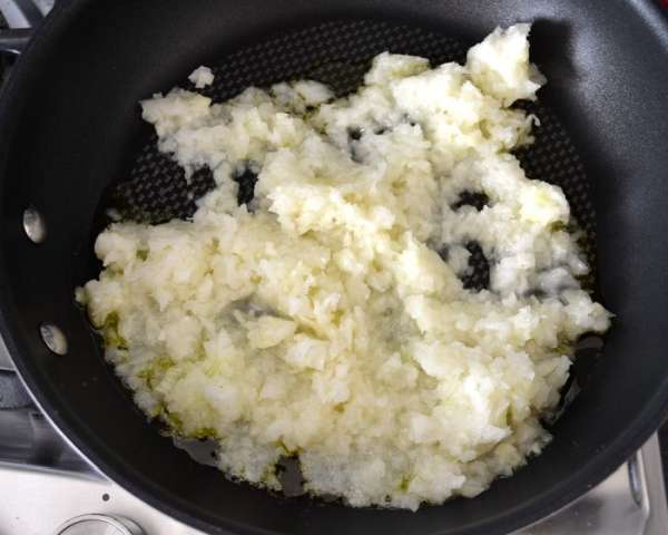 Приготовить мясной соус. Мясо курицы и индейки пропустить через мясорубку. Также измельчить крупную (!) луковицу и чеснок (я порубила в блендере). Большую сковороду разогреть и выложить измельченные лук и чеснок, добавить совсем немного овощного бульона (или воду) и потушить пару минут до посветления лука. 