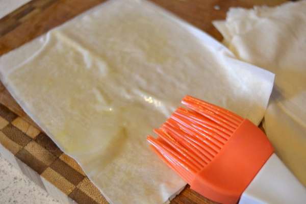 Размороженное тесто нарезать на квадратики, подходящего под ваши формы размера. Каждый лист промазать оливковым маслом и сложить в стопочку друг на друга в количестве 6 листов. Должно получиться 6 стопочек по 6 листиков в каждой. Размороженное тесто нарезать на квадратики, подходящего под ваши формы размера. Каждый лист промазать оливковым маслом и сложить в стопочку друг на друга в количестве 6 листов. Должно получиться 6 стопочек по 6 листиков в каждой.