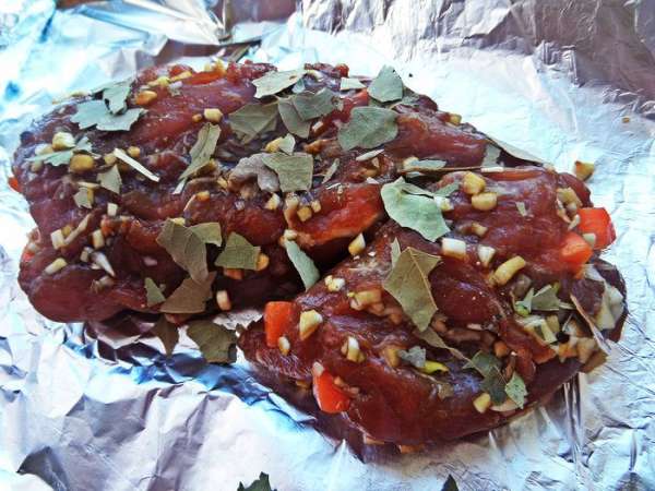 Перенести на фольгу и раскрошить на мясо несколько лавровых листиков.